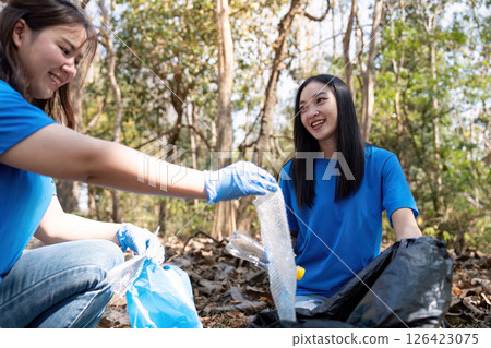 Volunteers collecting garbage in a forest, promoting environmental awareness and community service Volunteers collecting garbage in a forest, promoting environmental awareness and community service 126423075
