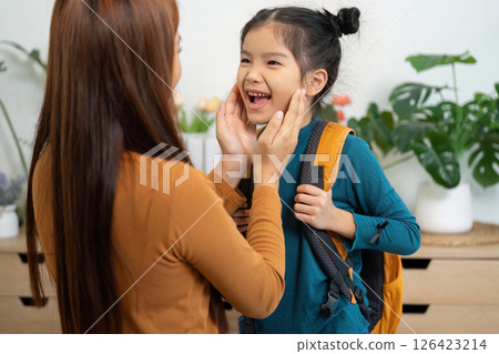 Joyful Goodbyes and Morning Love. A mother tenderly interacts with her daughter before she heads to school. 126423214