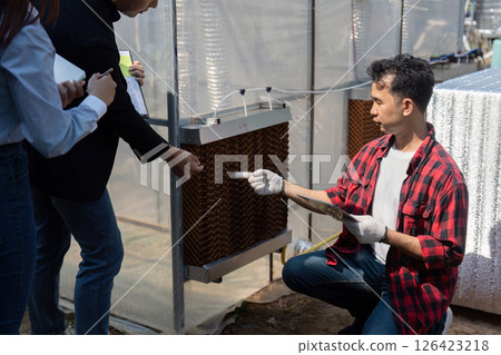 Engagement and Renewable Energy Innovation. A contractor shows a team of professionals the application of solar technology in a sustainable project. 126423218
