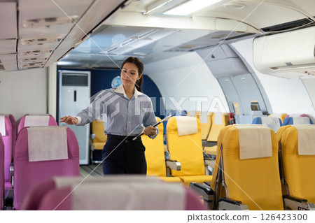 Business travel preparation with airline staff checking passenger seating Business travel preparation with airline staff checking passenger seating 126423300