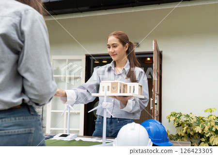 Sustainability engineer presenting eco-friendly building designs outdoors 126423305