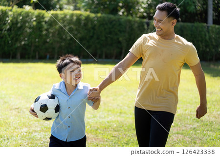 Activity: Father and Son Playing Soccer Together with Joy 126423338