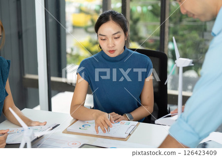 Team Collaboration on ESG Initiatives. Professionals discussing sustainability strategies in a modern office. Team Collaboration on ESG Initiatives. Professionals discussing sustainability strategies in a modern office. 126423409