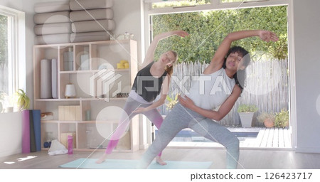 Image of white light spots over diverse teenage girls practicing yoga together Image of white light spots over diverse teenage girls practicing yoga together 126423717