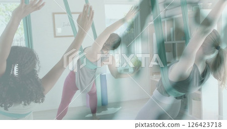Image of green leaves over diverse female instructor and teenage girls practicing aerial yoga Image of green leaves over diverse female instructor and teenage girls practicing aerial yoga 126423718