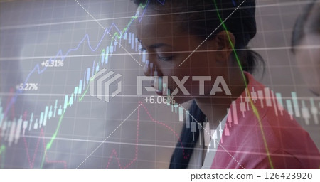 Image of data processing over diverse female colleagues using tablet 126423920