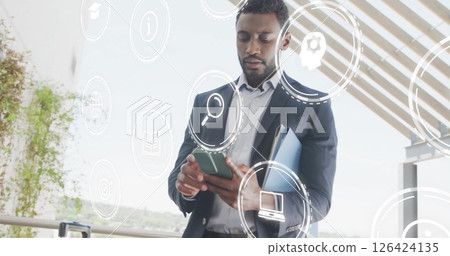 Image of media icons over african american businessman using smartphone Image of media icons over african american businessman using smartphone 126424135