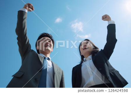 Two business people celebrating their success under the blue sky 126424598