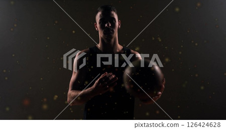 Image of moving spots over caucasian male basketball player holding basketball 126424628