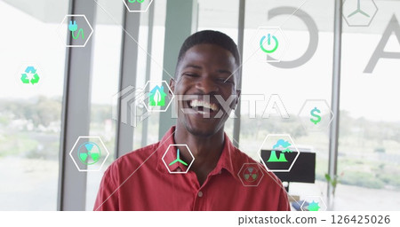 Image of ecology icons over biracial businessman smiling in office Image of ecology icons over biracial businessman smiling in office 126425026