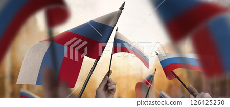 Russia flags in their hands on a blurred urban background 126425250
