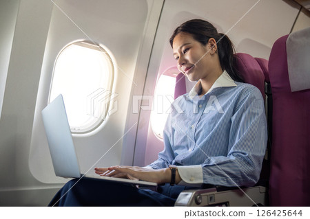 Business travel productivity with passenger working on a laptop onboard 126425644
