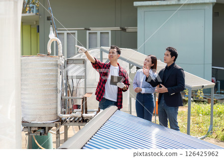 Team collaboration on solar energy. Professionals inspecting solar energy systems and discussing operational efficiency outdoors. 126425962