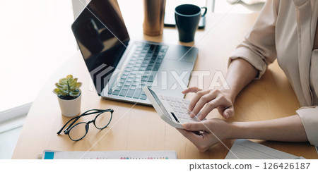 Close up view of bookkeeper or financial inspector hands making report, calculating or checking balance. Home finances, investment, economy, saving money or insurance concept Close up view of bookkeeper or financial inspector hands making report, calculating or checking balance. Home finances, investment, economy, saving money or insurance concept 126426187