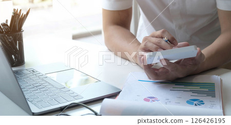 Close up Businessman using calculator and laptop for do math finance on wooden desk in office and business working background, tax, accounting, statistics and analytic research concept Close up Businessman using calculator and laptop for do math finance on wooden desk in office and business working background, tax, accounting, statistics and analytic research concept 126426195