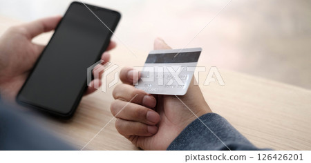 Online payment,Man's hands holding a credit card and using smart phone for online shopping 126426201