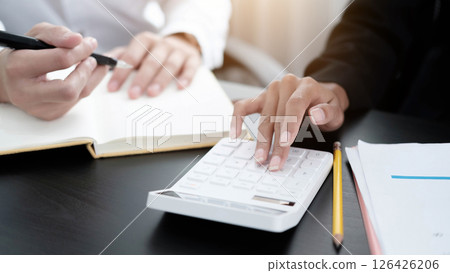 Close up Businessman and partner using calculator and laptop for calaulating finance, tax, accounting, statistics and analytic research concept 126426206