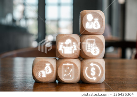 Wooden blocks with financial icons symbolizing debt management and financial planning on a wooden table. 126426304