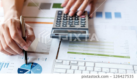Close up accountant or financial expert analyze business report graph and finance chart at corporate office. Concept of finance economy, banking business and stock market research 126427535