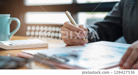 Accountant using a calculator to calculate the numbers. Accounting , Accountancy from financial report and calling to consultant, Calculation Concept. Accountant using a calculator to calculate the numbers. Accounting , Accountancy from financial report and calling to consultant, Calculation Concept. 126427536