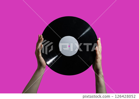 Hands are Holding a Vinyl Record against a Vibrant Pink Background that Looks Aesthetic 126428052