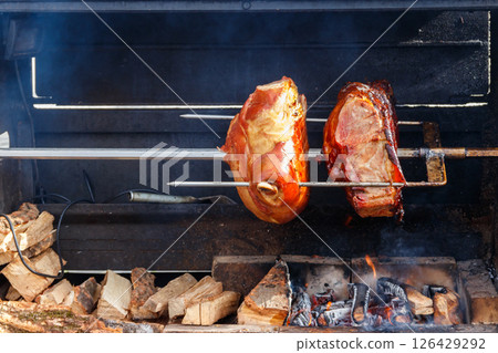 Czech smoked ham cooking on charcoal spit roaster in Prague streets, Czech Republic 126429292