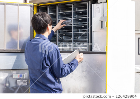 一名男子正在為自動販賣機加料 一名男子正在為自動販賣機加料 126429904