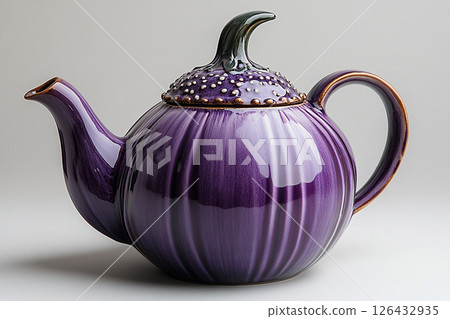 Ceramic teapot in shape of a purple eggplant in a rustic style on a white background. 126432935