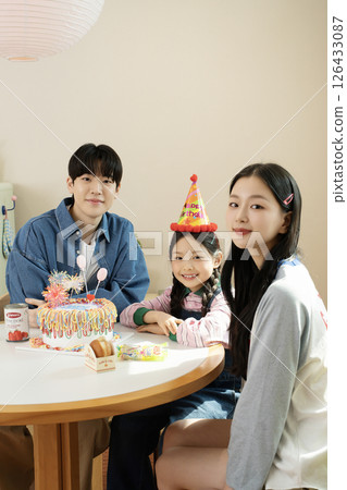 A family enjoying their daughter's birthday party at home 126433087