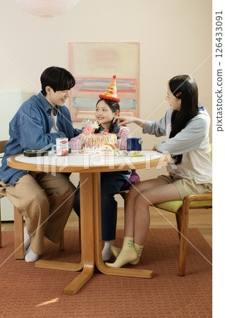 A family enjoying their daughter's birthday party at home 126433091