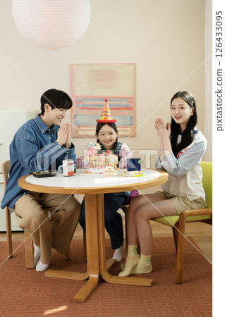 A family enjoying their daughter's birthday party at home 126433095