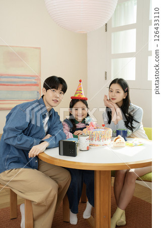A family enjoying their daughter's birthday party at home A family enjoying their daughter's birthday party at home 126433110