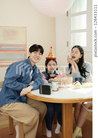 A family enjoying their daughter's birthday party at home 126433111