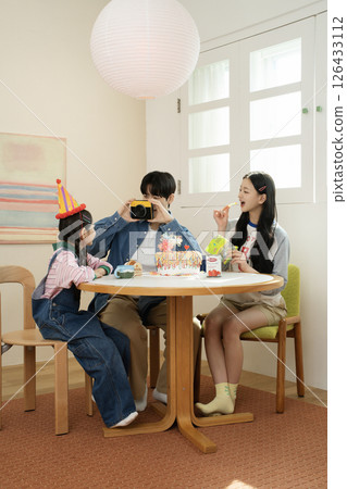 A family enjoying their daughter's birthday party at home A family enjoying their daughter's birthday party at home 126433112
