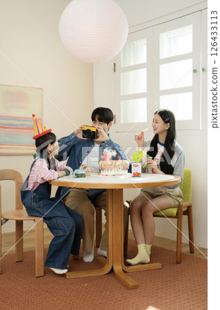 A family enjoying their daughter's birthday party at home 126433113