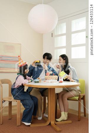 A family enjoying their daughter's birthday party at home A family enjoying their daughter's birthday party at home 126433114