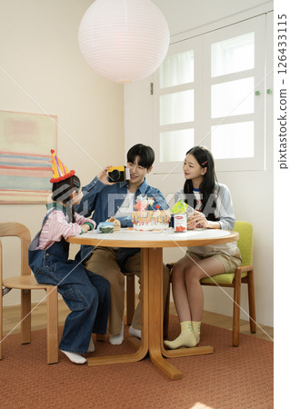 A family enjoying their daughter's birthday party at home 126433115