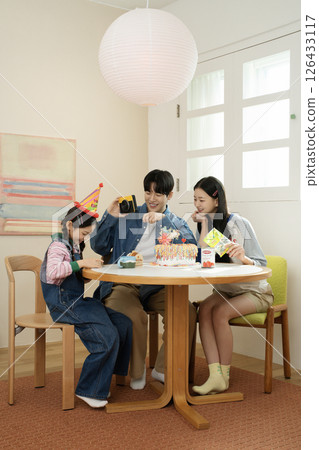 A family enjoying their daughter's birthday party at home A family enjoying their daughter's birthday party at home 126433117