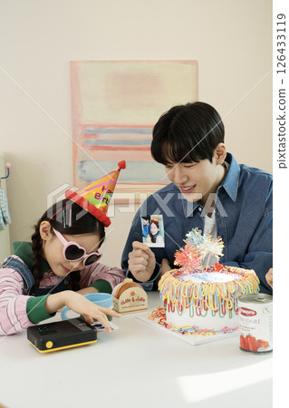 A family enjoying their daughter's birthday party at home 126433119