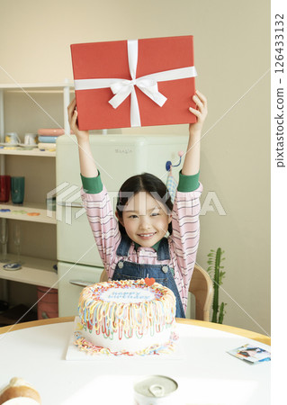 A cute little girl happy to receive a birthday present 126433132