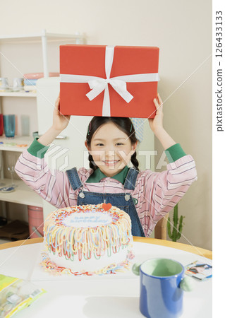 A cute little girl happy to receive a birthday present 126433133
