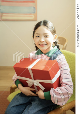 A cute little girl happy to receive a birthday present A cute little girl happy to receive a birthday present 126433136