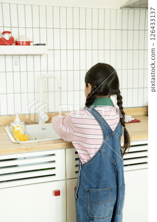 Back view of a child washing his hands in the kitchen 126433137