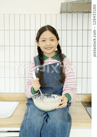 Child sitting on the sink and whipping bubbles with a whisk Child sitting on the sink and whipping bubbles with a whisk 126433160