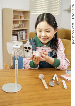 A cute child YouTuber who shoots beauty vlog content while holding his smartphone upright. A cute child YouTuber who shoots beauty vlog content while holding his smartphone upright. 126433192