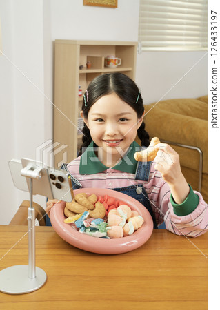 A cute child YouTuber who stands up on his smartphone and films a mukbang A cute child YouTuber who stands up on his smartphone and films a mukbang 126433197
