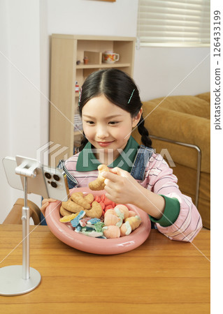 A cute child YouTuber who stands up on his smartphone and films a mukbang 126433199