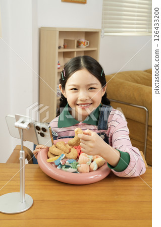 A cute child YouTuber who stands up on his smartphone and films a mukbang 126433200