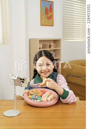 A cute child YouTuber who stands up on his smartphone and films a mukbang A cute child YouTuber who stands up on his smartphone and films a mukbang 126433201