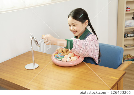 A cute child YouTuber who stands up on his smartphone and films a mukbang A cute child YouTuber who stands up on his smartphone and films a mukbang 126433205